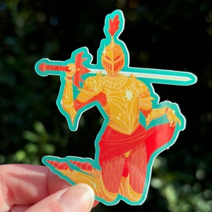 May include: A sticker of a golden knight kneeling with a sword, wearing a red cape and a golden helmet with a red plume. The knight is on a teal background.
