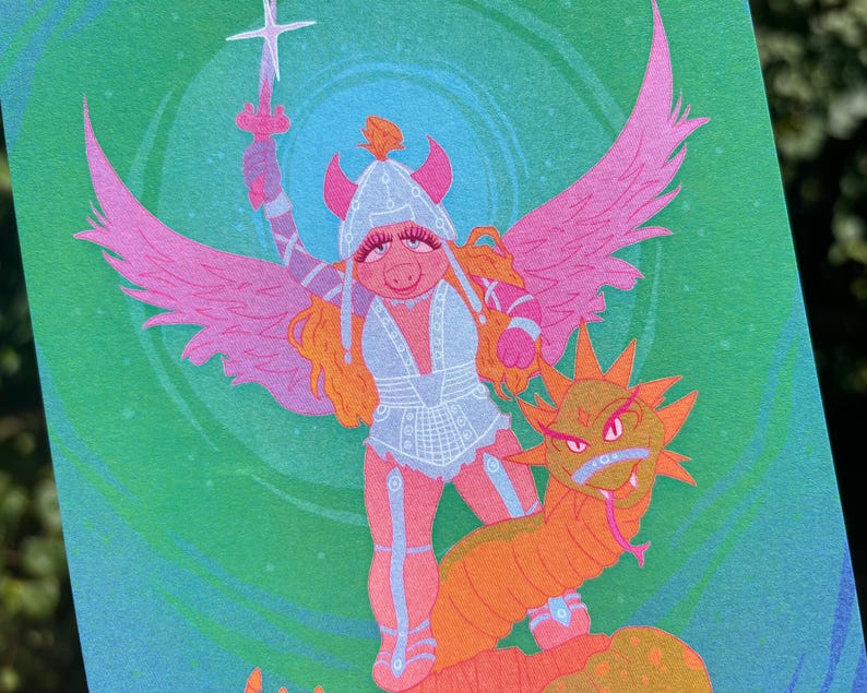 May include: A whimsical illustration features a pig-like character in armor, holding a sword, with pink wings and a dragon. The artwork is set against a green background with a swirling pattern. The character has orange hair and is wearing a helmet.