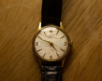 Reloj vintage Smiths Astral de 17 joyas chapado en oro con correa original - Reloj británico de cuerda manual de la década de 1960 - Hermosa esfera de lino