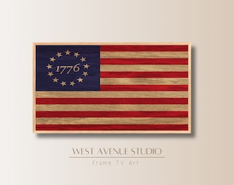 Può includere: Una bandiera americana in legno incorniciata con 13 strisce rosse e bianche e un cantone blu con un cerchio di 13 stelle e l'anno 1776. La bandiera è in una cornice di legno.