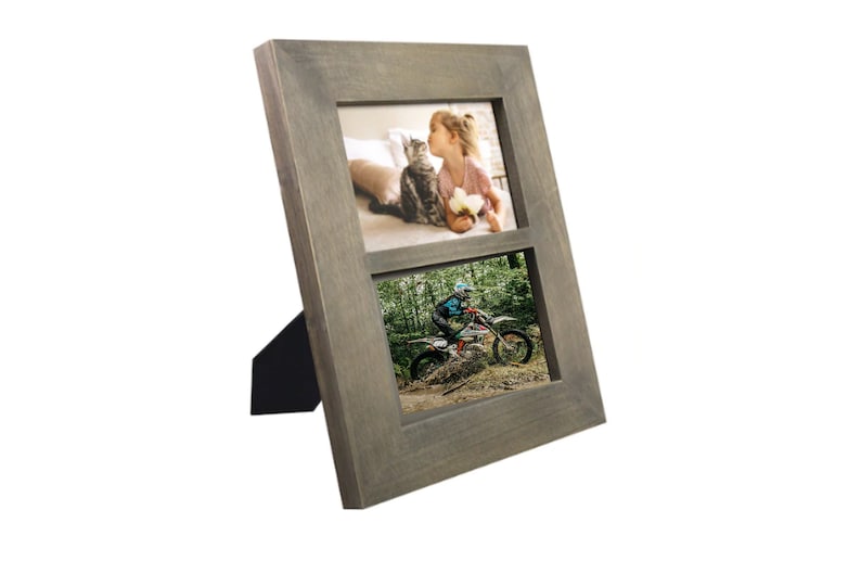 May include: A gray wooden picture frame with two openings for photos. The top opening shows a girl kissing a cat, and the bottom opening shows a person riding a dirt bike.