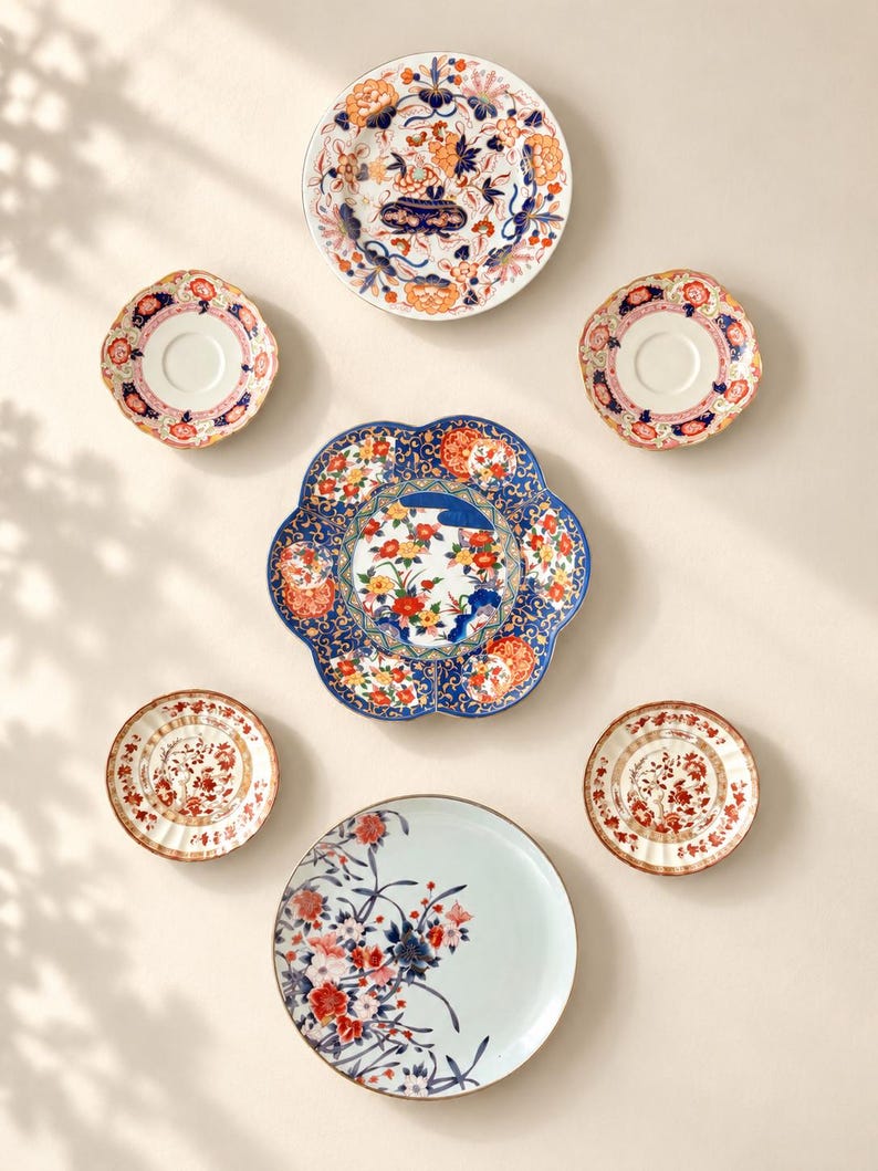 Pu&ograve; includere: Un set di sette piatti e piattini in ceramica con vari motivi floreali nei colori blu, arancione, rosso e bianco. Il set comprende un grande piatto smerlato, un piatto rotondo con base azzurra e diversi piattini pi&ugrave; piccoli abbinati.