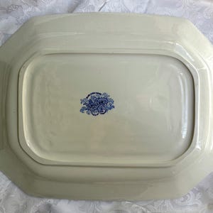 May include: A rectangular cream-colored ceramic serving platter with beveled edges. The underside features a central blue floral stamp with the text Willow and Burleigh Ware, indicating the manufacturer and pattern name in a decorative script.