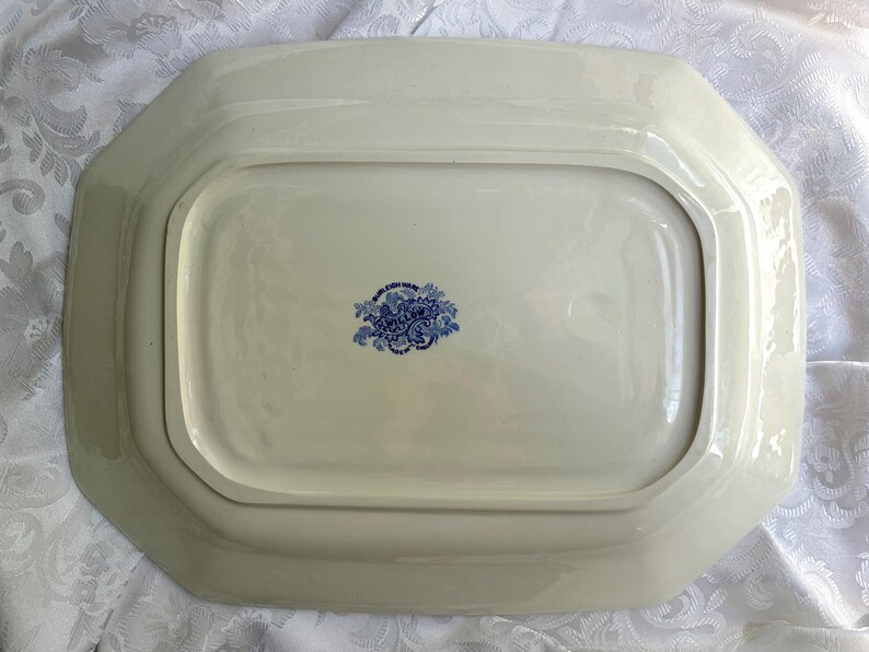 May include: A rectangular cream-colored ceramic serving platter with beveled edges. The underside features a central blue floral stamp with the text Willow and Burleigh Ware, indicating the manufacturer and pattern name in a decorative script.