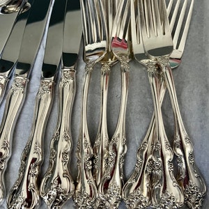 Puede incluir: Un juego de cubiertos de plata con mangos ornamentados. Los tenedores tienen un dise&ntilde;o tradicional con un patr&oacute;n floral decorativo. El juego incluye tanto cuchillos como tenedores.