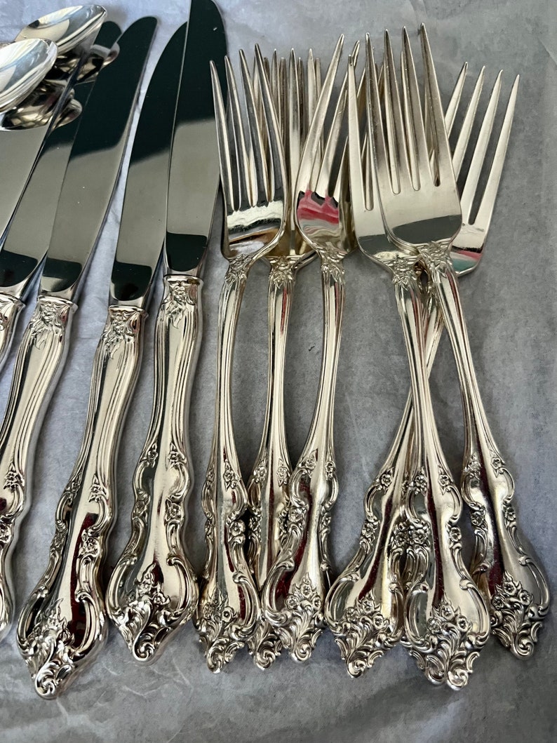 Puede incluir: Un juego de cubiertos de plata con mangos ornamentados. Los tenedores tienen un dise&ntilde;o tradicional con un patr&oacute;n floral decorativo. El juego incluye tanto cuchillos como tenedores.