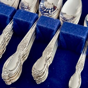 K&ouml;nnte beinhalten: Ein Set versilbertes Besteck in einem blauen Samt-Etui. Das Besteck umfasst L&ouml;ffel, Gabeln und Messer.