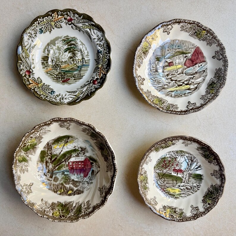 Pode incluir: Quatro tigelas de cer&acirc;mica com bordas recortadas e centros na cor creme. Cada tigela apresenta uma ilustra&ccedil;&atilde;o de paisagem detalhada e &uacute;nica no centro e uma borda decorativa de folhas, trigo e bagas em tons de castanho e verde.
