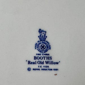 May include: A blue and white ceramic plate with a Royal Doulton logo and the text "BOOTHS 'Real Old Willow' TC 1126 ROYAL DOULTON 1981".