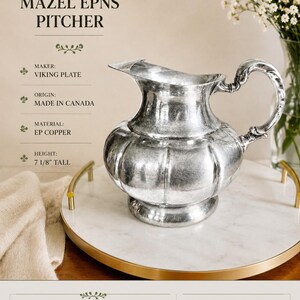 May include: A silver-plated pitcher by Viking Plate, made in Canada, featuring a rounded, ribbed body and a curved handle. The pitcher is 7 1/8 inches tall and is labeled as Mazel EPNS. The surface shows visible patina and minor scratches.
