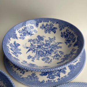 K&ouml;nnte beinhalten: Ein Set aus blauen und wei&szlig;en Keramikschalen mit einem Blumenmuster. Die Schalen haben einen gewellten Rand und ein zartes Blumenmuster.