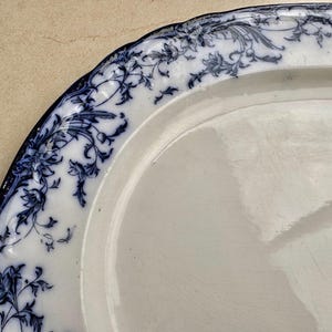Puede incluir: Plato ovalado blanco para servir con un dise&ntilde;o floral azul alrededor del borde. El patr&oacute;n azul presenta flores y hojas estilizadas. El plato tiene un borde ligeramente festoneado.