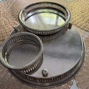 May include: A silver-toned metal serving set featuring a large circular tray with a raised gallery rim and two smaller, detachable circular bowls with matching pierced lattice sides and decorative ball feet on the base.