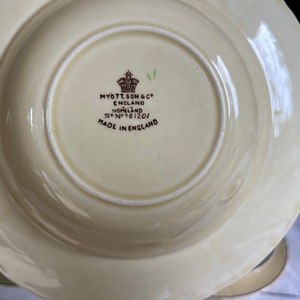 May include: A white ceramic bowl with a brown rim and a brown inscription on the bottom that reads "Myott, Son & Co. England Homeland Reg No 761201 Made in England".