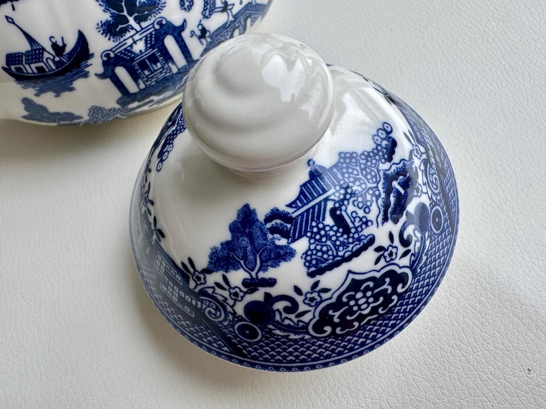 K&ouml;nnte beinhalten: Blau-wei&szlig;er Porzellan-Teekannen-Deckel mit traditionellem chinesischem Design. Der Deckel hat einen wei&szlig;en Knopf mit einem erhabenen Design.