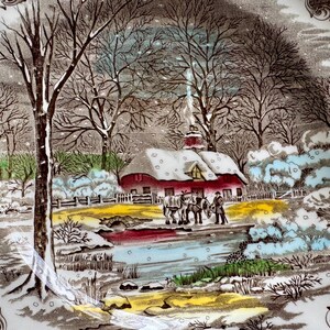 May include: A vintage ceramic plate with a winter scene. The plate features a snow-covered farmhouse with a red roof, trees, and a frozen pond. The scene is painted in brown, blue, and white tones.