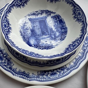 K&ouml;nnte beinhalten: Ein Set aus vier blauen und wei&szlig;en Keramiktellern mit einem Blumendesign und einer Cottage-Szene mit Hasen. Die Teller sind perfekt f&uuml;r eine Bauernhaus- oder Landhausk&uuml;che.