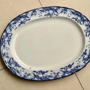 Puede incluir: Plato ovalado para servir con centro blanco y borde floral azul. El borde tiene un borde festoneado. El plato mide aproximadamente 40 cm de largo y 30 cm de ancho.