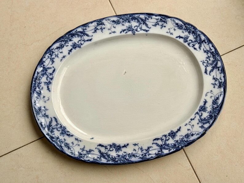 Puede incluir: Plato ovalado para servir con centro blanco y borde floral azul. El borde tiene un borde festoneado. El plato mide aproximadamente 40 cm de largo y 30 cm de ancho.