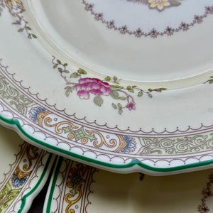 Puede incluir: Un juego de tres platos de cer&aacute;mica blanca con un patr&oacute;n floral verde y dorado. Los platos tienen un borde festoneado y un borde verde.