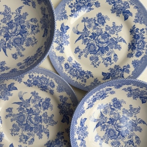 K&ouml;nnte beinhalten: Set aus vier blauen und wei&szlig;en Keramikschalen mit einem Blumenmuster. Die Schalen haben einen wei&szlig;en Hintergrund mit blauen Blumen und V&ouml;geln.