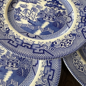 K&ouml;nnte beinhalten: Ein Satz von vier blauen und wei&szlig;en Keramik-Dinnertellern mit einem Weidenmuster. Die Teller sind &uuml;bereinander gestapelt, wobei der oberste Teller das vollst&auml;ndige Muster zeigt.