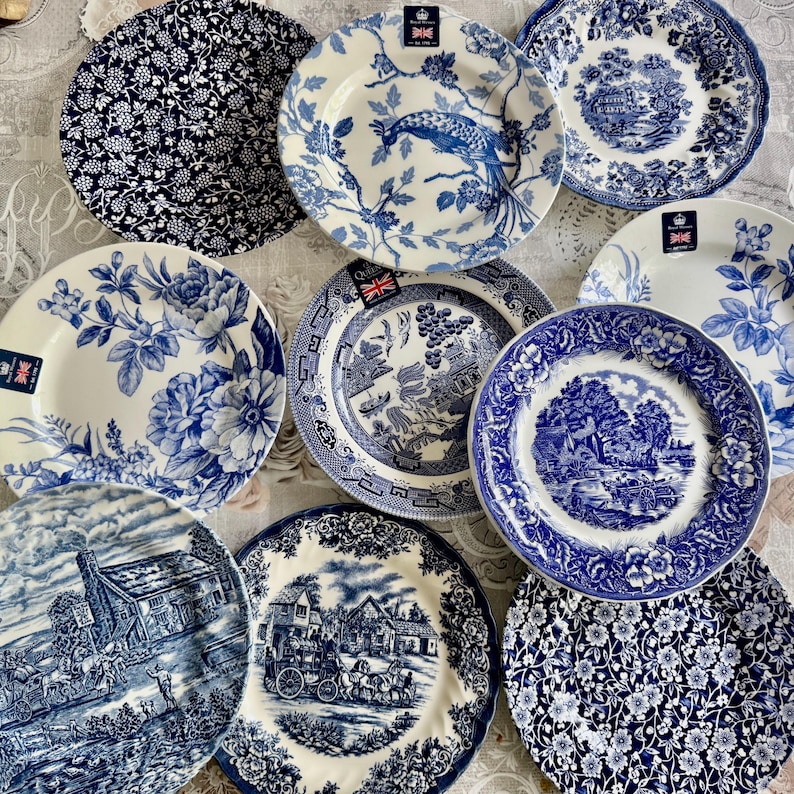 May include: A collection of ten round ceramic plates featuring various blue and white patterns, including floral motifs, pastoral landscapes, a peacock design, and traditional willow scenes, each marked with a small Royal Stafford label.