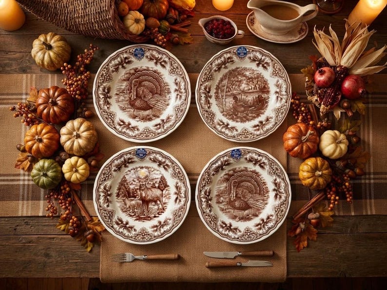Op de afbeelding: Vier ronde keramische borden met bruine transferware-illustraties van kalkoenen en herten, geschikt op een tafel met decoratieve pompoenen, kalebassen en herfstbladeren. Elk bord heeft een gedetailleerde rand en een centrale natuursc&egrave;ne.