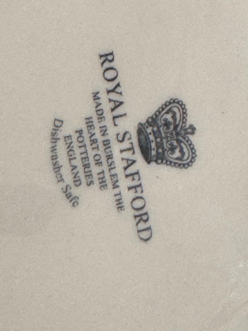K&ouml;nnte beinhalten: Royal Stafford Logo mit einer Krone und dem Text "Made in Burslem the heart of the potteries England Dishwasher Safe".