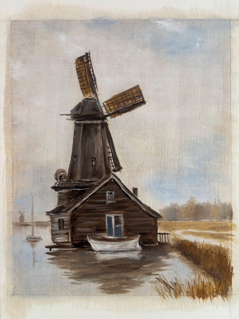 May include: An oil painting depicting a dark brown wooden windmill with rotating blades positioned next to a small white boat on a calm body of water. The scene includes a grassy bank, a distant sailboat, and a soft, muted sky in shades of blue and gray.