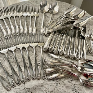 May include: A set of silver flatware with ornate floral designs on the handles. The set includes forks, knives, and spoons.