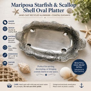 May include: An oval sand-cast recycled aluminum platter featuring a raised relief design of starfish and scallop shells. The platter is footed and measures 18 inches long by 10 inches wide. The text reads Mariposa Starfish & Scallop Shell Oval Platter.