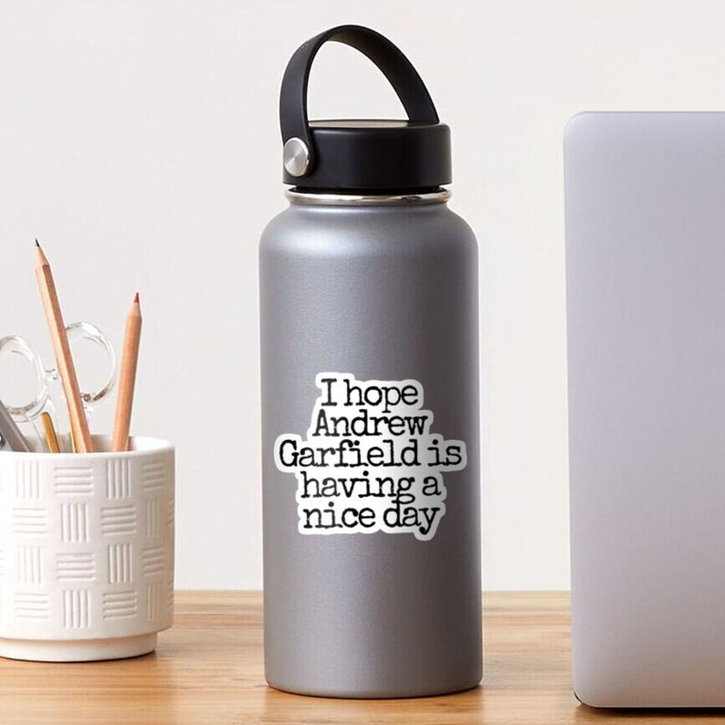 May include: A white water bottle with a black sticker that says "I hope Andrew Garfield is having a nice day."