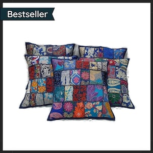 Puede incluir: Un conjunto de cojines decorativos de patchwork con diseños coloridos. Los cojines presentan una variedad de patrones y colores, incluyendo azul, rojo, naranja y morado. El texto "Bestseller" se encuentra en la esquina superior izquierda.