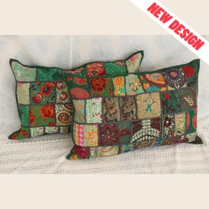 Peut inclure: Deux coussins rectangulaires avec un motif patchwork. Les coussins présentent un fond vert avec divers carrés de tissu colorés. Les carrés sont ornés de motifs floraux et cachemire. Les coussins ont une bordure verte. Le texte "NEW DESIGN" est visible.
