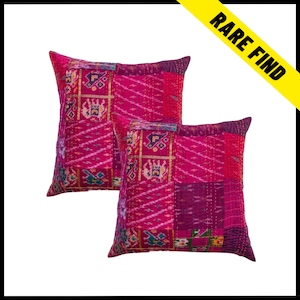 May include: Two square decorative pillows with a patchwork design. The pillows are primarily shades of pink and magenta, with geometric and patterned sections. The pillows have a stitched texture and a 'Rare Find' banner in the upper right corner.