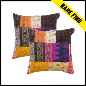 May include: Two square patchwork cushions in vibrant colours including orange, yellow, purple, and black. The cushions have a stitched texture and a decorative border. The image includes the text "RARE FIND" in a yellow banner.