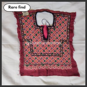 May include: A vintage, hand-stitched textile with a geometric pattern in shades of red, pink, green, and yellow. The top has a keyhole neckline and frayed edges. The text "Rare find" is in a white oval, and the text "@RuralKanthaWork" is also visible.
