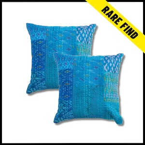 May include: Two square cushions in shades of blue with a patchwork design. The cushions have a quilted texture with visible stitching. A yellow banner in the top right corner reads "RARE FIND".