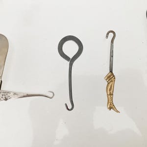 4 crochets à boutons anciens, 2 avec dates de brevet, un en nacre et tige en argent et un en acier.