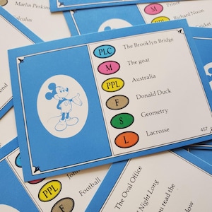 May include: Blue cards with a Mickey Mouse illustration and text. The cards feature various topics like "The Brooklyn Bridge" and "Donald Duck". The cards have colored oval shapes with letters and numbers.