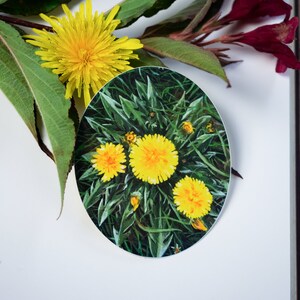 May include: Close-up of a sticker featuring a cluster of yellow dandelions with green leaves. The dandelions are in full bloom and have a bright yellow color.