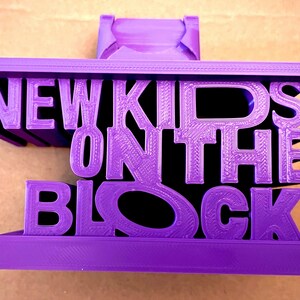 May include: A purple 3D printed object shaped like the words "New Kids on the Block".
