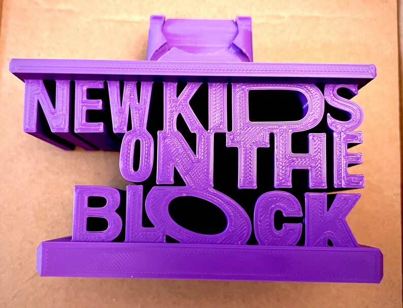 May include: A purple 3D printed object shaped like the words "New Kids on the Block".