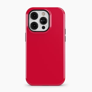 May include: A glossy red phone case with a black camera module. The case has a smooth, reflective surface and a rounded design. The camera module features three lenses and a flash.