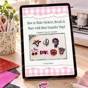 Peut inclure: Une tablette numérique affichant un guide intitulé How to Make Stickers, Decals & More with Heat Transfer Vinyl par Tonya Worley. La couverture présente une bordure à carreaux roses et une image centrale de six autocollants en vinyle colorés, dont une vache, un cœur, un crâne, des cerises, le mot love et des lèvres.