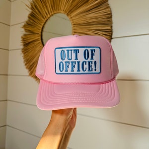 May include: Pink trucker hat with a blue and white patch that says "OUT OF OFFICE!"