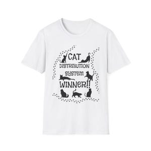 May include: White t-shirt with a black graphic design of cats and paw prints. The text on the shirt reads "Cat Distribution System Winner!"