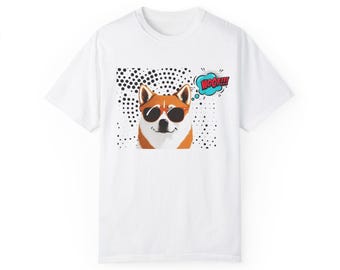 May include: White t-shirt featuring a graphic of a Shiba Inu dog wearing sunglasses and a speech bubble that says "WOOF!!". The dog is set against a black and white polka dot background.
