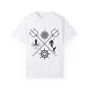 May include: White t-shirt with a black graphic design featuring a compass, crossed tridents, an octopus, a mermaid, and a ship's wheel.